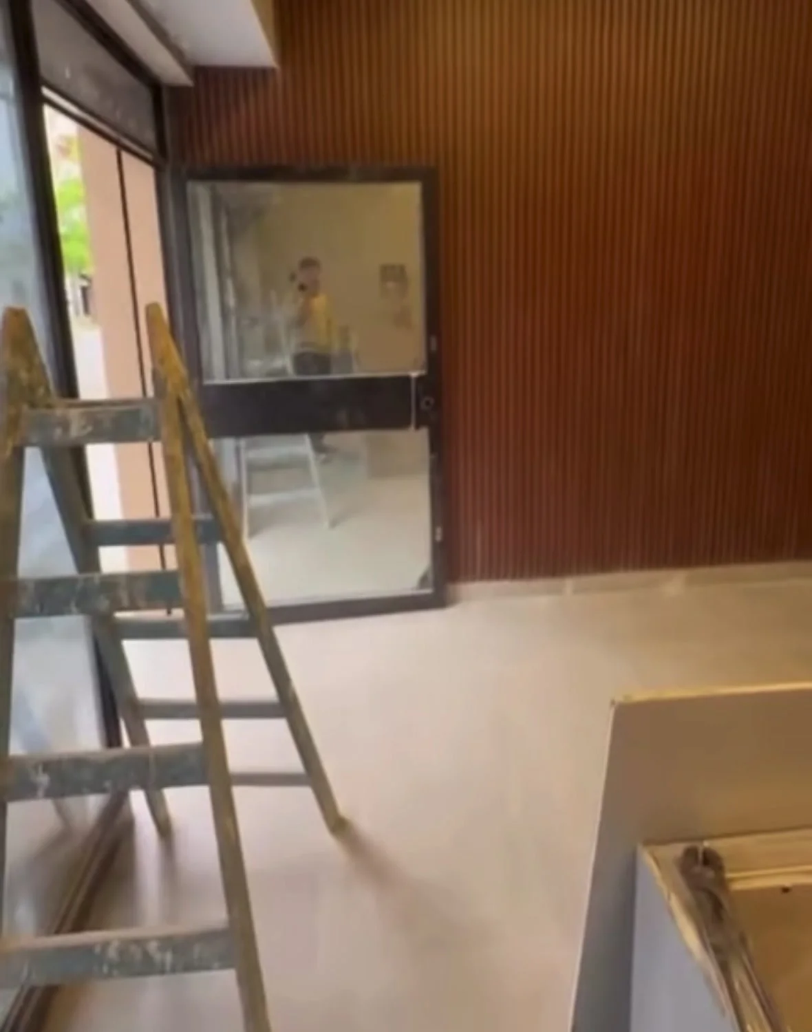 Interior de local gastronómico en obra con revestimiento de listones de madera